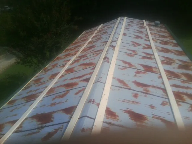 Rusted metal roof panels with new wood purlins before replacement — Storm Damage Roof Repair in Claypool by Roofing Brothers