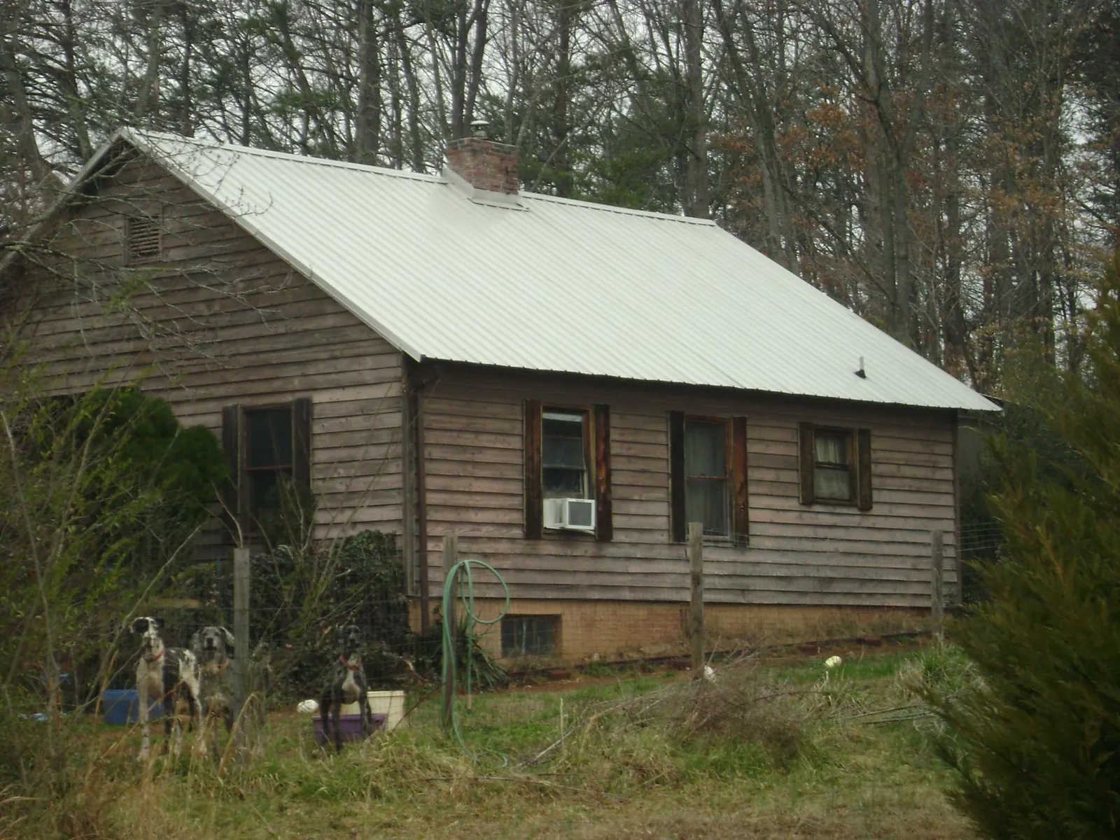 White metal roof on an old wood sided farmhouse, from a Metal Roof Installation job in Claypool
